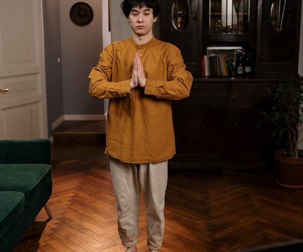 A senior man practicing a standing balance yoga pose with focus and stability.