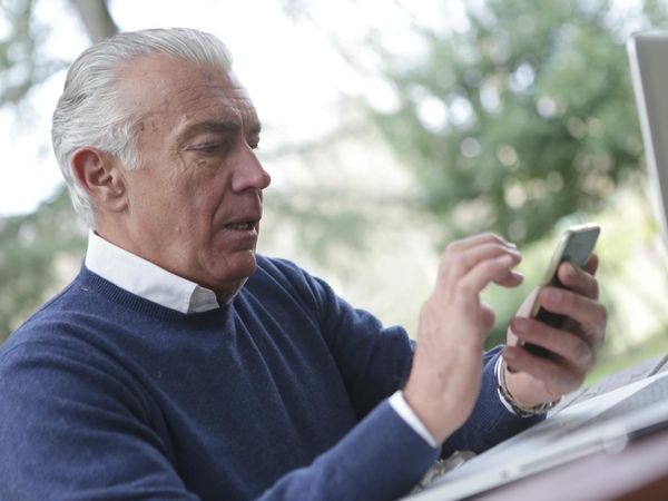 Close-up of a senior person's hands in a meditative pose, with soft focus background.